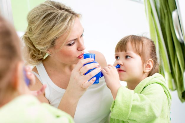matka s dievčatkom ktoré drží v ruke modrú konvičku na preplach nosa