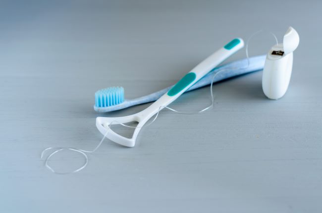 Koncepcia zdravia ústnej hygieny. Detailné dentálne nástroje zubná kefka a škrabka na jazyk.