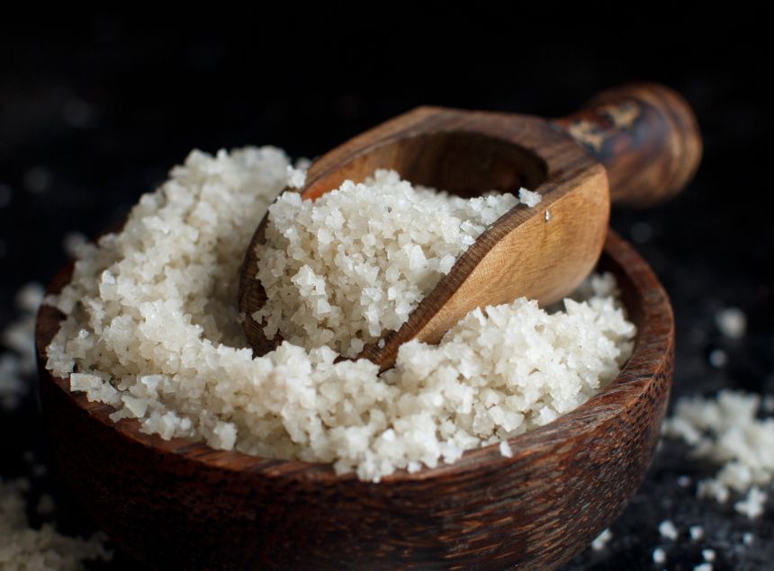 Keltská soľ v drevenej miske na drevenej lyžičke.